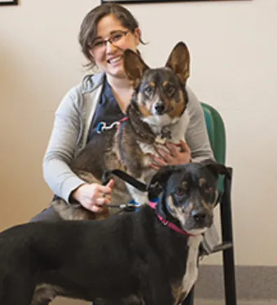Vet assistant Teresa sitting with two dogs
